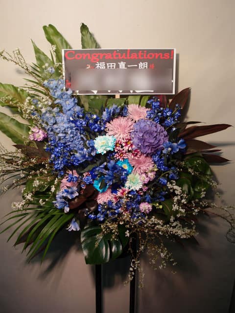 贈先:福田真一朗様宛 場所:晴れたら空に豆まいて(渋谷区代官山町) イメージ:青、ロック 用途:公演御祝 その他:黒背景白抜き文字のスタンド札